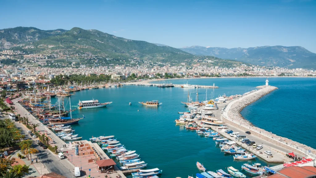 Uitzicht op Alanya in Turkije met haven, boten, kustlijn en bergen op de achtergrond