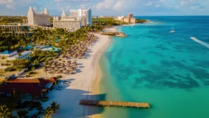 Luchtfoto van een strand op Aruba met resorts, palapa's en turquoise zee